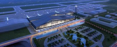 An elderly man sits patiently in the airport, his worn briefcase beside him, a contemplative expression on his face.