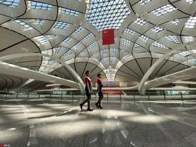 机场大巴行驶在宽阔的道路上，远处可见现代化的建筑。