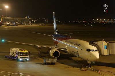 哈尔滨机场大巴夜间行驶,车灯照亮银色道路